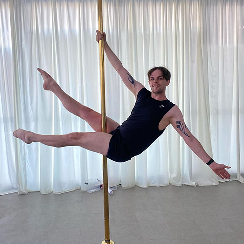 man hanging on a pole extending his legs