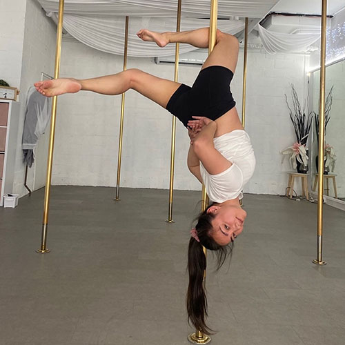 woman hanging upside down on a pole