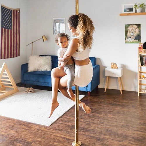 woman hanging on her home pole with her baby